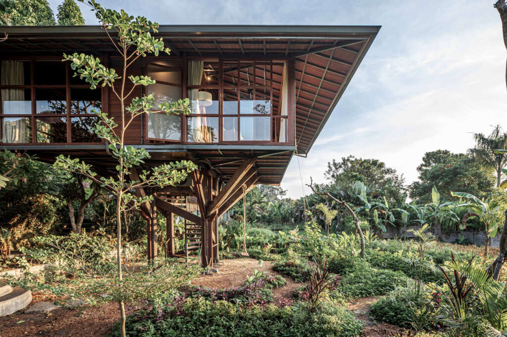 This wooden treehouse in Bali is embedded into lush rice fields